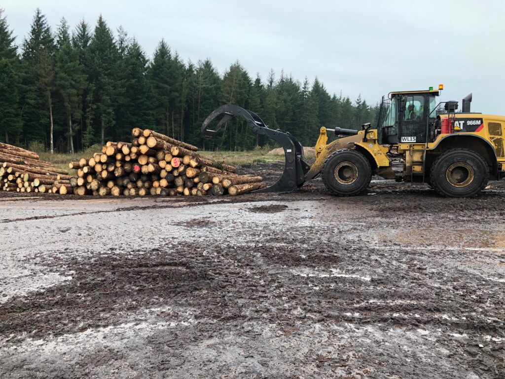 Picture of an Ulrich Timber Handling grapple lifting logs on a client site.