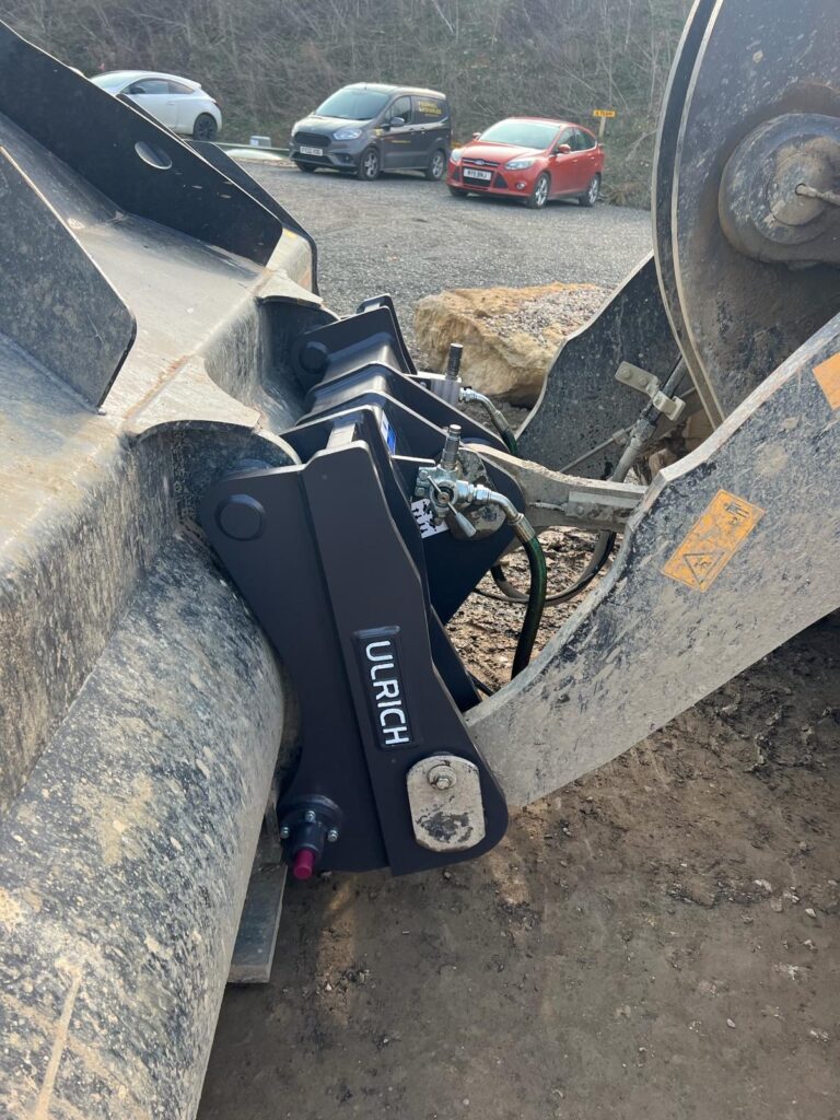 Black Ulrich quick coupler attached to a loader.